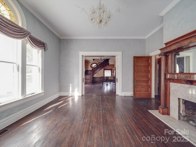 unfurnished living room featuring a chandelier, hardwood / wood-style flooring, visible vents, a high end fireplace, and baseboards