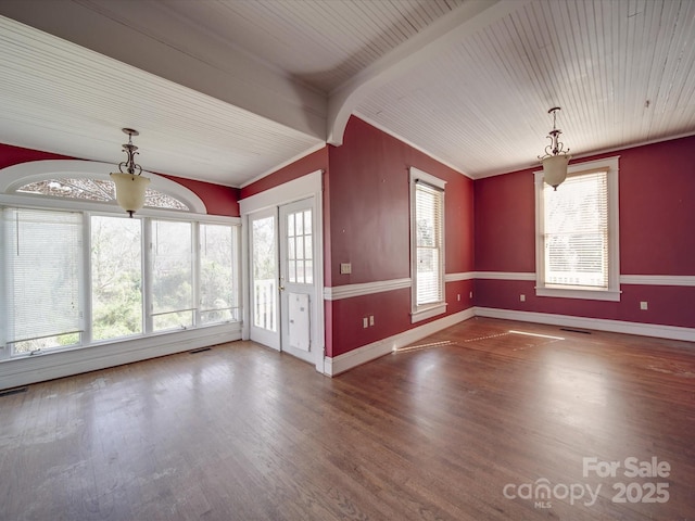 unfurnished living room with a healthy amount of sunlight, baseboards, and wood finished floors