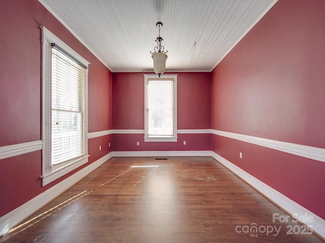 unfurnished room with baseboards, wood finished floors, and ornamental molding