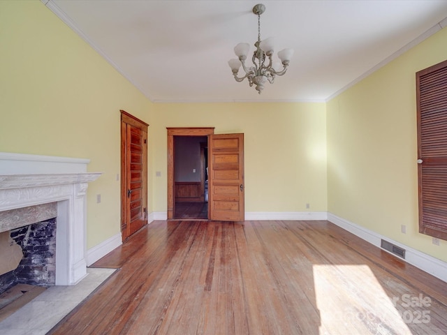 unfurnished living room featuring hardwood / wood-style flooring, a fireplace, visible vents, and crown molding