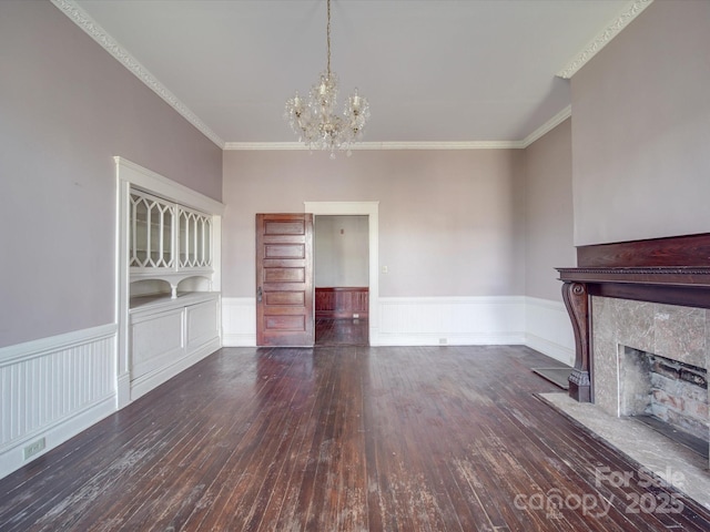 unfurnished living room featuring a wainscoted wall, a fireplace, and hardwood / wood-style floors