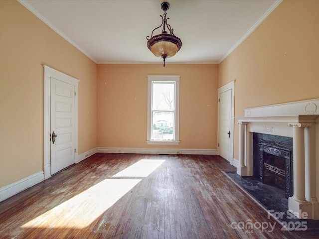 unfurnished living room with ornamental molding, baseboards, a premium fireplace, and wood finished floors