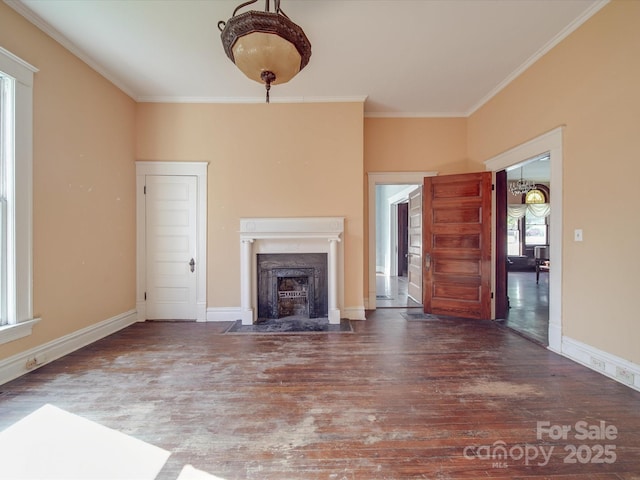 unfurnished living room featuring baseboards, a fireplace with flush hearth, wood finished floors, and crown molding