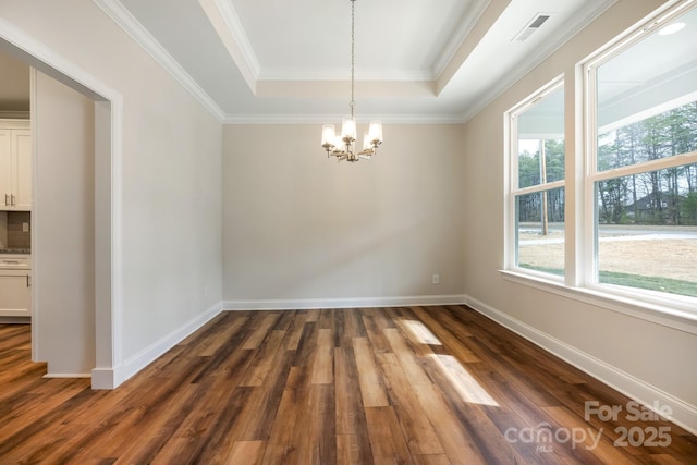 empty room with dark wood-style floors, baseboards, a tray ceiling, and a chandelier