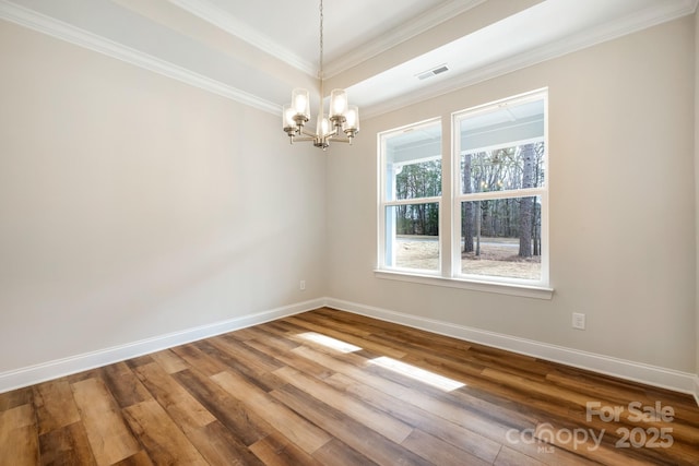 unfurnished room featuring an inviting chandelier, baseboards, ornamental molding, and wood finished floors