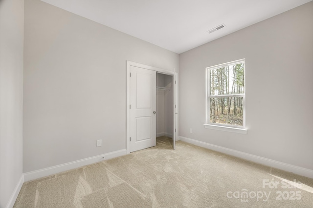 unfurnished bedroom featuring carpet, a closet, visible vents, and baseboards