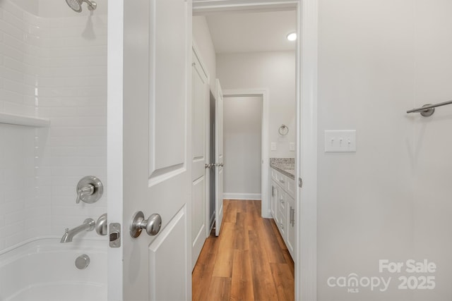 full bath featuring shower / washtub combination, wood finished floors, and vanity