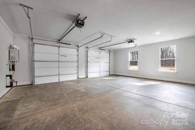 garage featuring a garage door opener, water heater, and baseboards