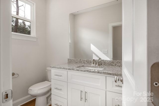 half bathroom featuring vanity and toilet