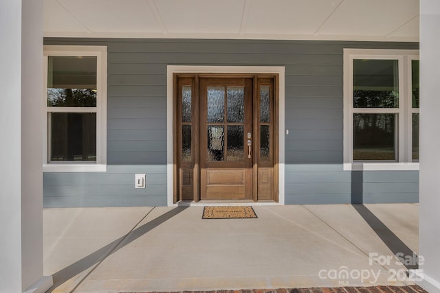 view of exterior entry featuring covered porch