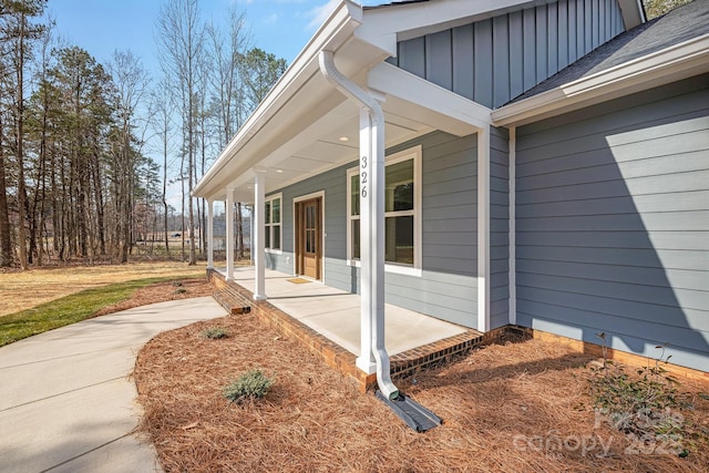 entrance to property featuring a porch, board and batten siding, and a shingled roof