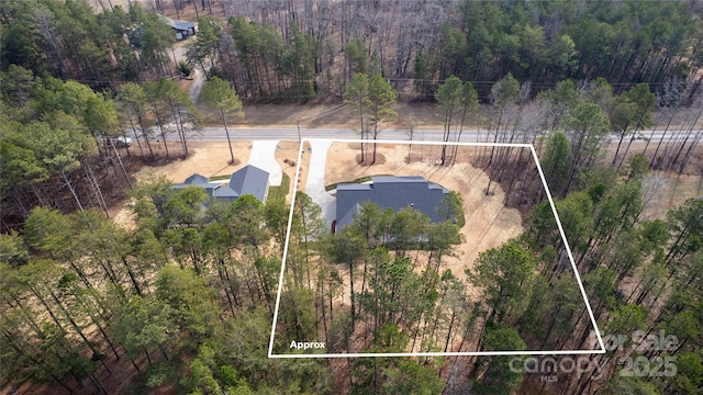 birds eye view of property featuring a forest view