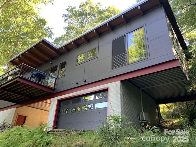 448 Mt Mitchell Dr, Burnsville, NC 28714 - view of side of home with a balcony, brick siding, and a garage
