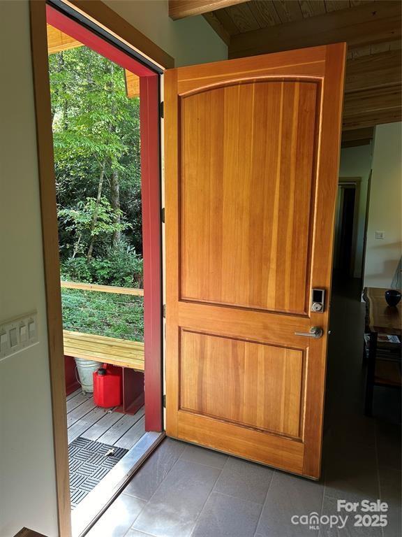 448 Mt Mitchell Dr, Burnsville, NC 28714 - doorway to outside featuring tile patterned floors and beam ceiling