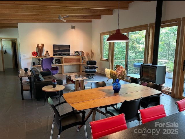 448 Mt Mitchell Dr, Burnsville, NC 28714 - dining room with visible vents, baseboards, beam ceiling, a wood stove, and tile patterned flooring