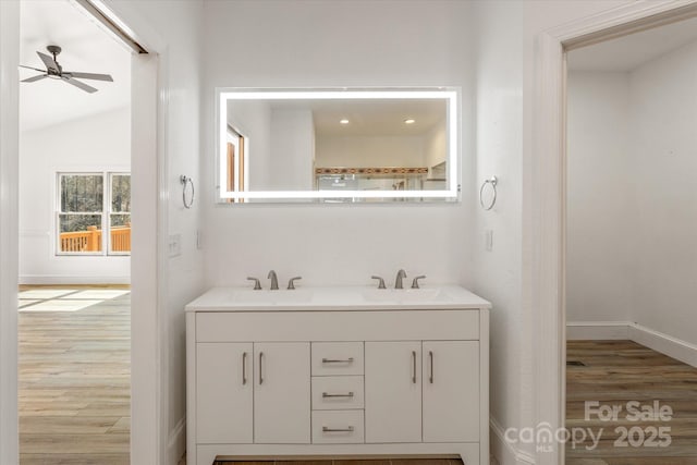 full bath with ceiling fan, double vanity, a sink, and wood finished floors