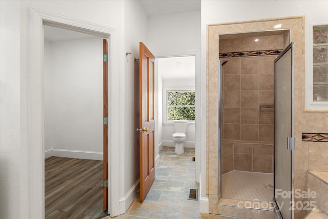 full bathroom featuring a stall shower, baseboards, visible vents, and toilet