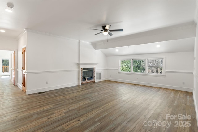 unfurnished living room featuring a fireplace, lofted ceiling, a ceiling fan, wood finished floors, and baseboards