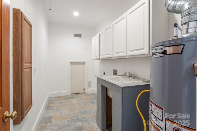 washroom featuring cabinet space, baseboards, hookup for an electric dryer, water heater, and washer hookup