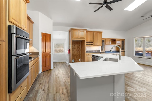 kitchen with a healthy amount of sunlight, a center island with sink, appliances with stainless steel finishes, and a sink