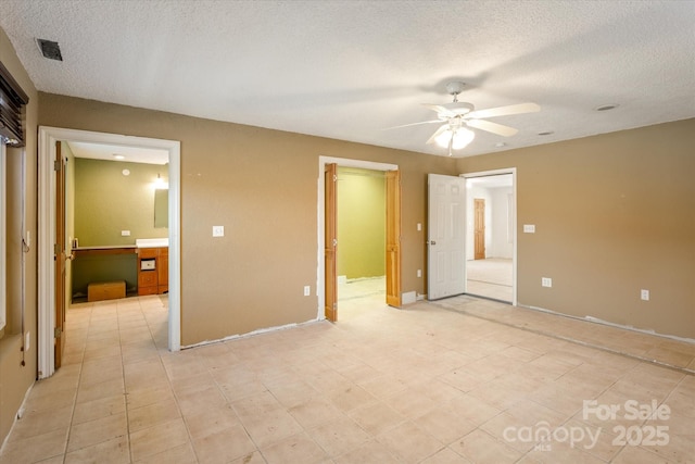 unfurnished bedroom featuring ensuite bathroom, visible vents, a textured ceiling, and a ceiling fan