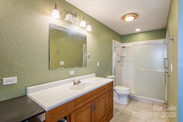 full bath with a textured wall, toilet, tile patterned floors, vanity, and a shower stall