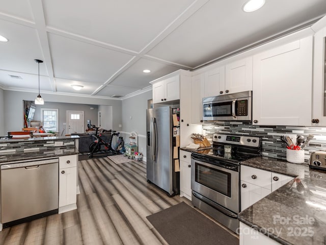 kitchen with dark stone counters, stainless steel appliances, decorative backsplash, white cabinetry, and open floor plan