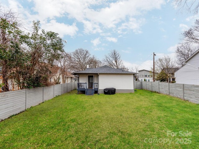 back of property with a yard and a fenced backyard