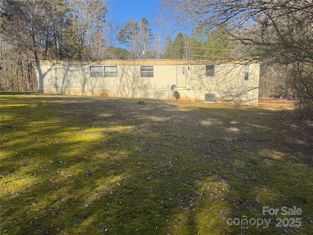 view of home's exterior with central AC and a yard