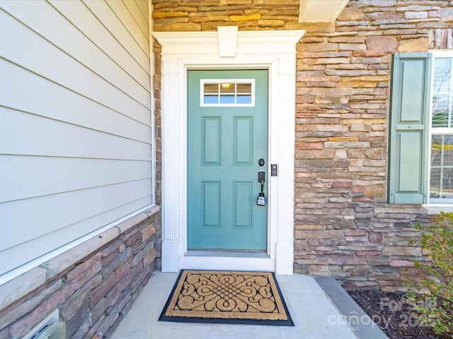 entrance to property featuring stone siding