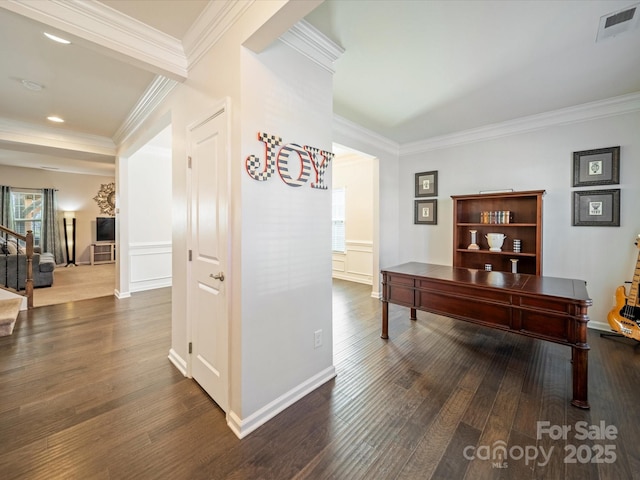 office space with baseboards, visible vents, wood finished floors, and ornamental molding