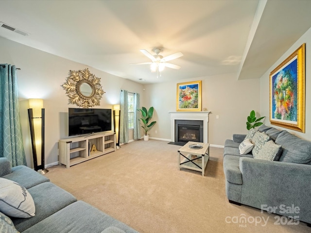 living area featuring visible vents, a fireplace with flush hearth, carpet flooring, ceiling fan, and baseboards