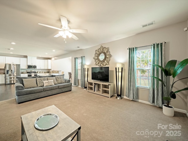 living area featuring ceiling fan, recessed lighting, light carpet, visible vents, and baseboards