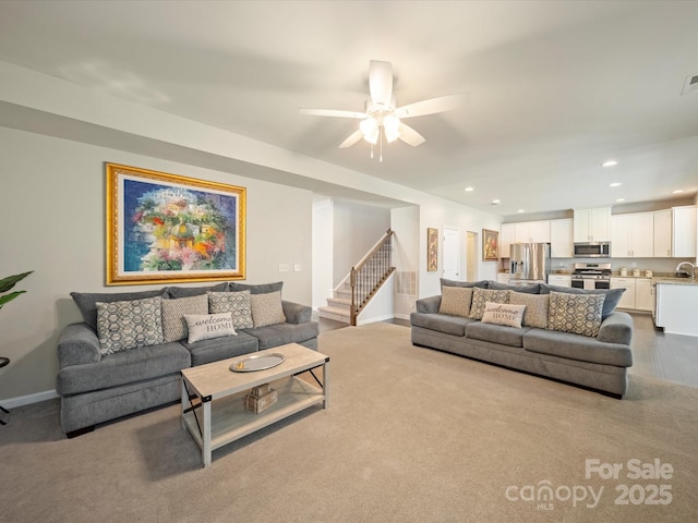 living area featuring baseboards, stairway, ceiling fan, and recessed lighting