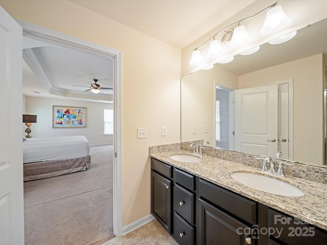 bathroom with ensuite bathroom, double vanity, a sink, and a raised ceiling