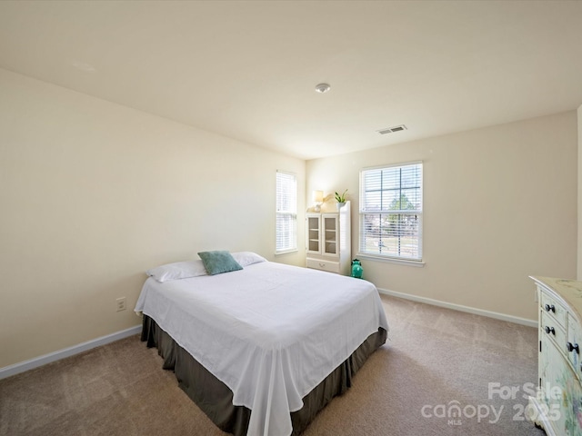 bedroom featuring light carpet, visible vents, and baseboards