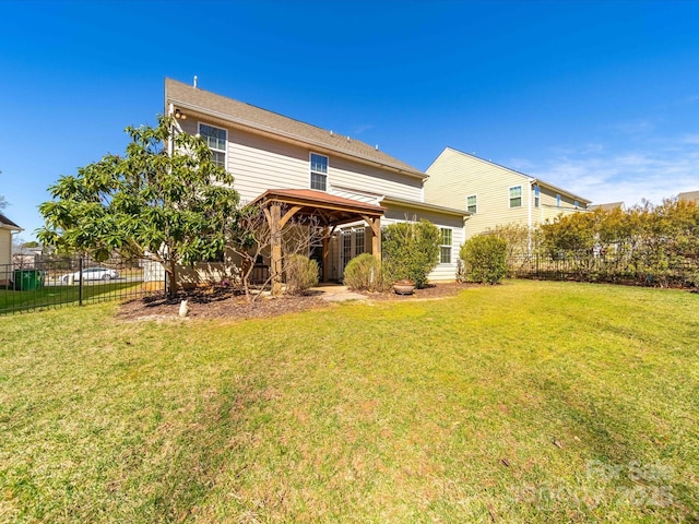 back of property featuring a yard, a gazebo, and fence