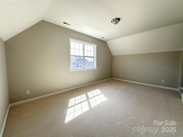 bonus room with lofted ceiling, carpet flooring, visible vents, and baseboards