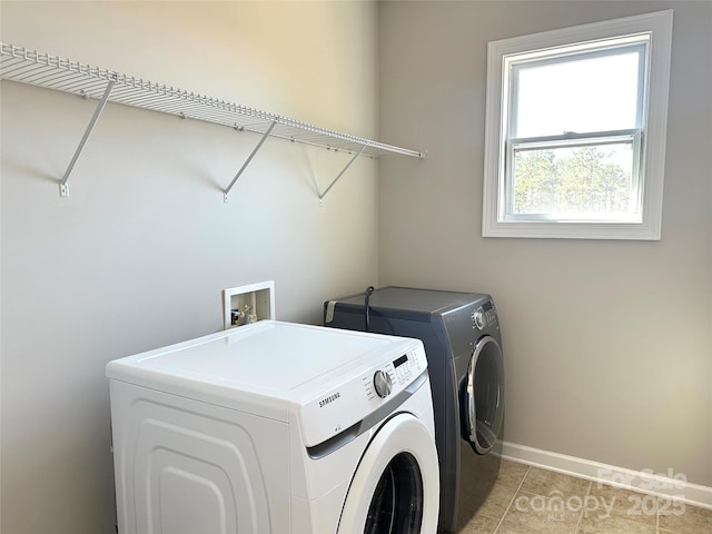 laundry room featuring laundry area, independent washer and dryer, light tile patterned flooring, and baseboards