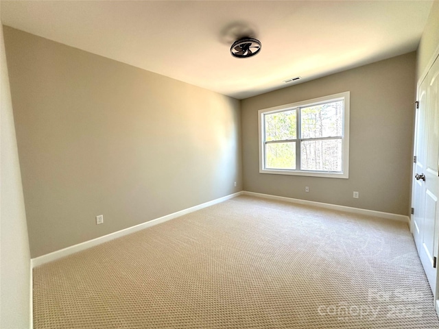 empty room with light carpet, visible vents, and baseboards