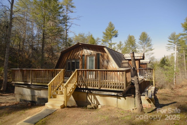 back of property featuring a deck, metal roof, stairway, and a gambrel roof