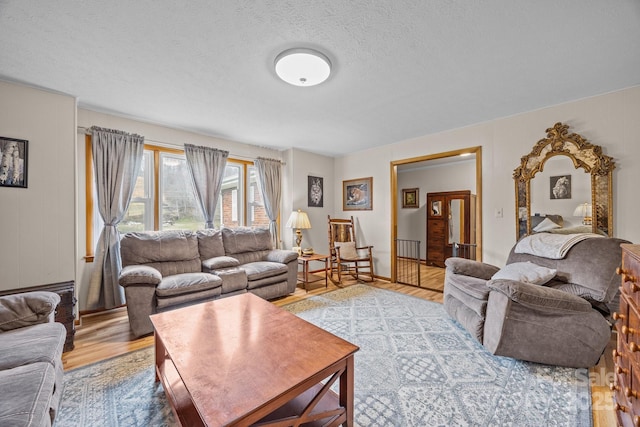 living area with a textured ceiling and light wood-style flooring