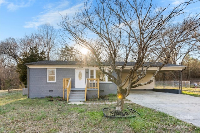 view of front facade featuring brick siding, fence, driveway, crawl space, and a carport