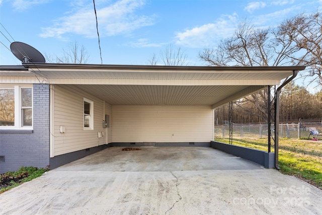 view of parking featuring driveway, fence, and an attached carport