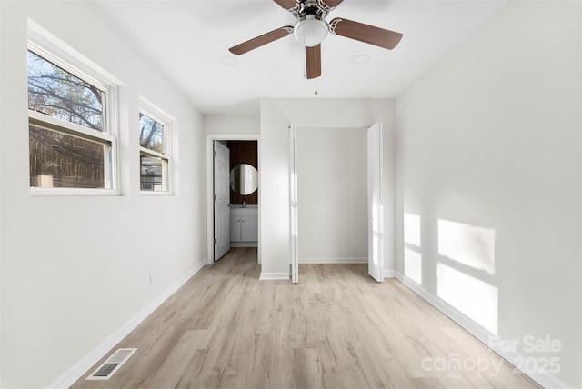 unfurnished bedroom featuring a ceiling fan, baseboards, visible vents, and light wood finished floors