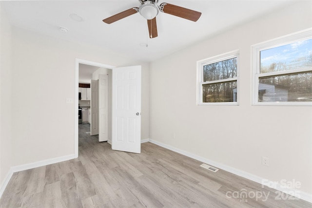 unfurnished bedroom with visible vents, ceiling fan, baseboards, and wood finished floors