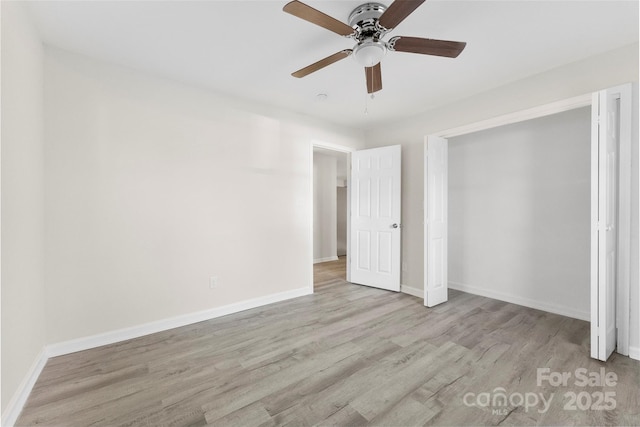 unfurnished bedroom with a ceiling fan, baseboards, and wood finished floors