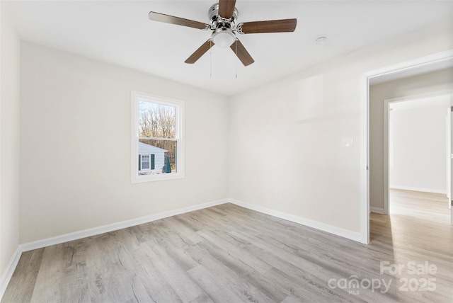 spare room with a ceiling fan, baseboards, and wood finished floors