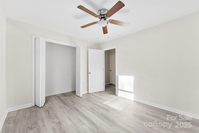 unfurnished bedroom featuring ceiling fan, a closet, light wood-style flooring, and baseboards