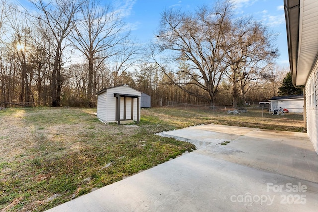 view of yard with a patio, a shed, an outdoor structure, and fence